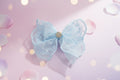 Blue lace bow with a gold center on a wooden surface