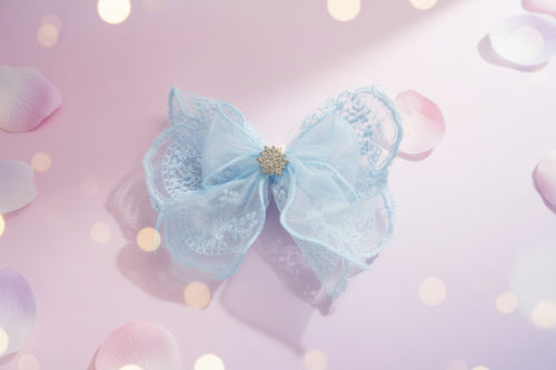 Blue lace bow with a gold center on a wooden surface
